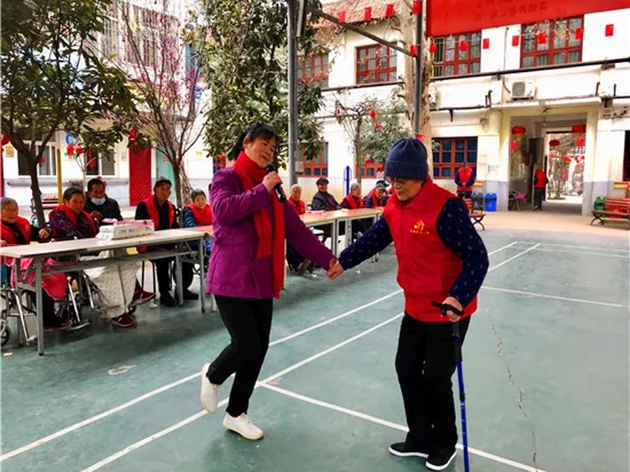 护理人员搀扶拄拐老人行走锻炼